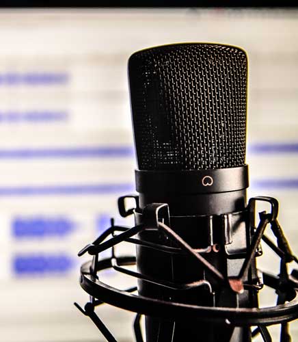 Microphone in front of a screen with audio from a voiceover demo on it