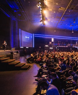 A large auditorium hosting a corporate event where you'd hire a voiceover artist, like Neil Williams to be you're voice of god voice over, announcing guests on stage and being a general event accouncer