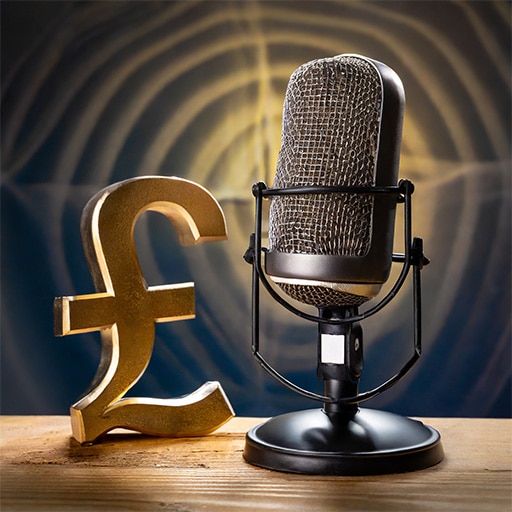 a microphone on a wooden surface, as used by Neil Williams British Male Voice Over Artist in his studio, next to a pound sign in gold to show the affordable voice over rates
